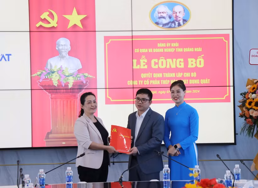 Bà Đinh Thị Hồng Minh (trái), Phó Bí thư Tỉnh ủy Quảng Ngãi trao Quyết định Bí thư Chi bộ Công ty Cổ phần Thép Hòa Phát Dung Quất cho ông Lưu Thanh Tùng. (Ảnh: Phạm Cường/TTXVN)