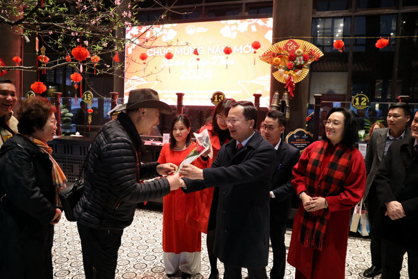 Chủ tịch UBND tỉnh Quảng Ninh Cao Tường Huy (thứ 2 bên phải) tặng hoa và lì xì cho du khách. (Ảnh: Đức Hiếu/TTXVN)