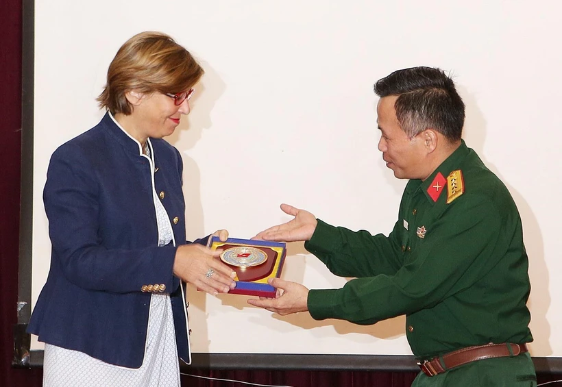 Đại tá Nguyễn Như Cảnh, Phó Cục trưởng Cục Gìn giữ hòa bình Việt Nam tặng quà lưu niệm cho bà Cynthia Petrigh - chuyên gia về Phòng chống bạo lực tình dục của Vương quốc Anh. (Ảnh: Dương Giang/TTXVN)