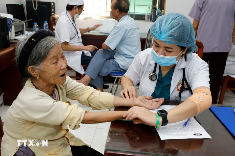 Cán bộ y tế chăm sóc sức khỏe cho người có công. (Ảnh: TTXVN)
