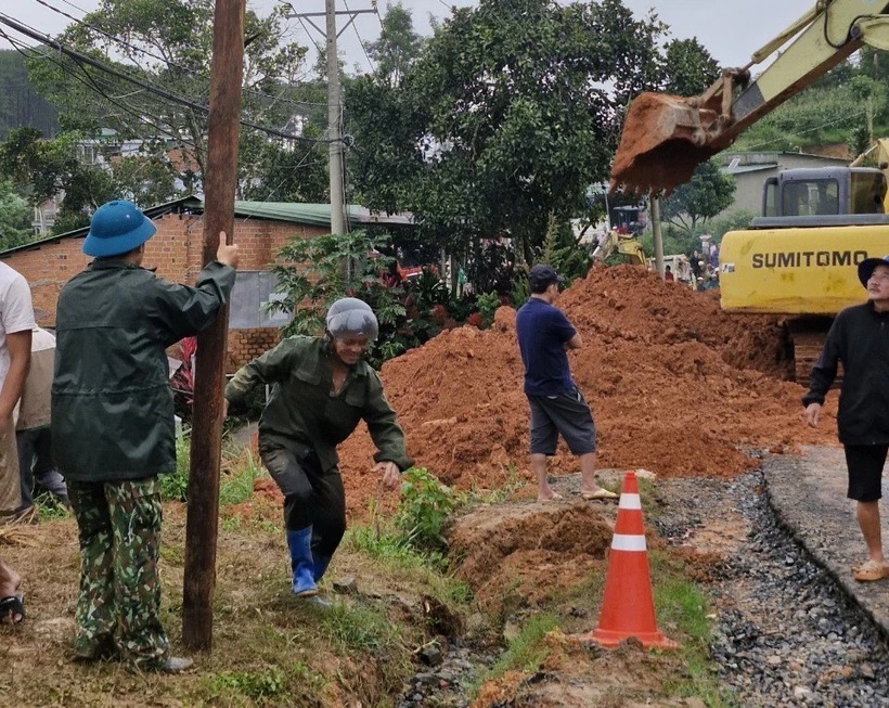 Lực lượng chức năng cùng thiết bị cơ giới triển khai công tác cứu hộ, giải tỏa hiện trường. (Ảnh: TTXVN phát)