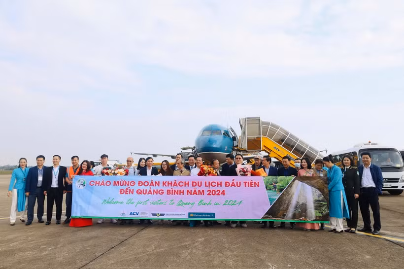 Lãnh đạo Sở Du lịch tỉnh Quảng Bình tặng hoa những du khách đến tỉnh đầu tiên trong năm 2024. (Ảnh: Công Thành/TTXVN)