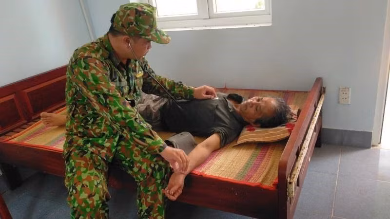 Cán bộ y tế Đồn Biên phòng thăm khám cho ngư dân gặp nạn. (Ảnh: TTXVN phát)