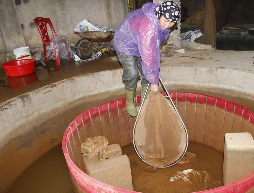 Bể lắng dẫn nước vào ao hồ tụ đầy bùn đỏ. (Ảnh: Quân Trang/TTXVN)