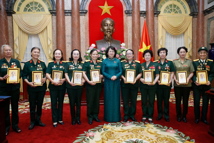 Phó Chủ tịch nước Đặng Thị Ngọc Thịnh tặng chân dung Chủ tịch Hồ Chí Minh cho các đại biểu nữ bộ đội Trường Sơn, thanh niên xung phong, dân quân hỏa tuyến, công nhân giao thông thời kỳ kháng chiến. (Ảnh: Lâm Khánh – TTXVN)
