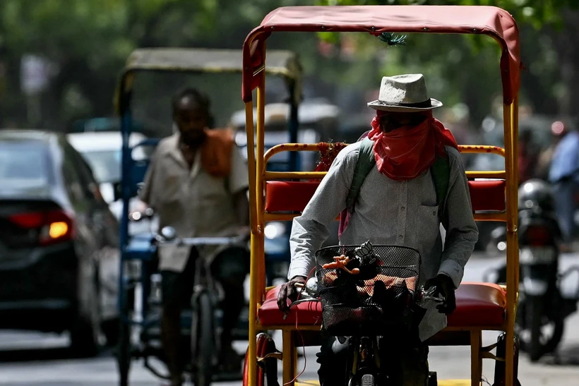 Người dân đội mũ và khăn để tránh nắng nóng tại New Delhi, Ấn Độ. (Ảnh: AFP/TTXVN)