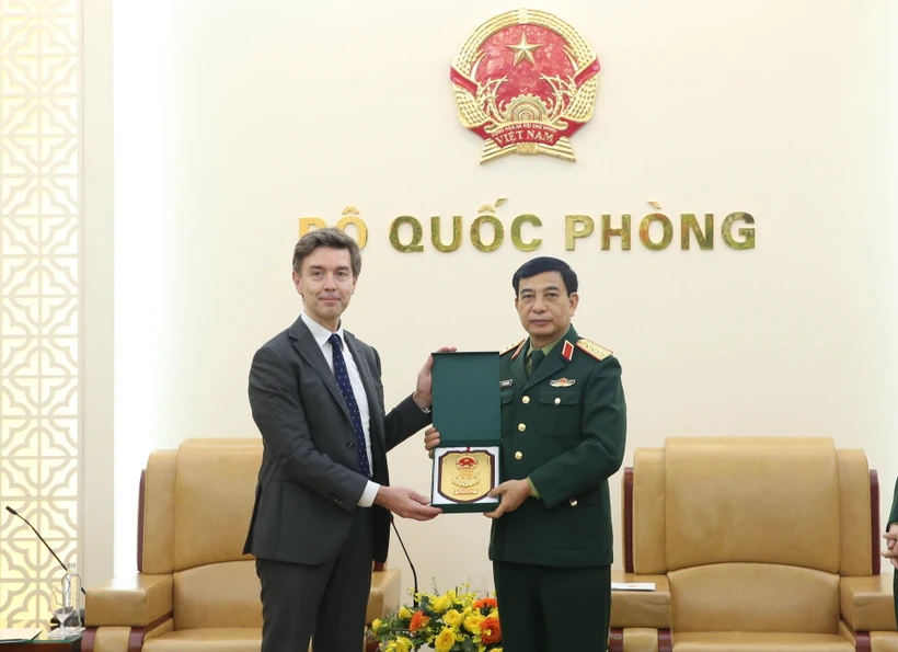 Đại tướng Phan Văn Giang tặng quà lưu niệm ông Julien Guerrier. (Ảnh: Hồng Pha/TTXVN phát)