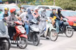 Khẩu trang, áo chống nắng là những thứ không thể thiếu của người dân khi tham gia giao thông. (Ảnh: Lê Đông/TTXVN)