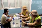 Nam tài xế làm việc với cảnh sát giao thông. (Ảnh: Công an cung cấp)