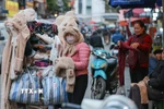 Người lao động, bán hàng trên phố che chắn kỹ chống rét. (Ảnh: Hoàng Hiếu/TTXVN)