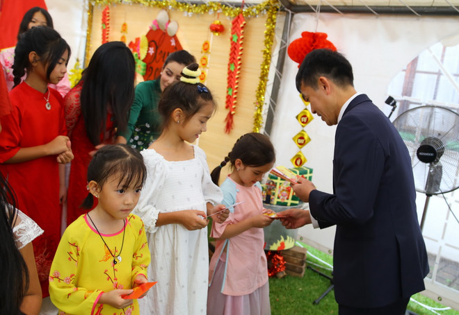 Tặng phong bao lì xì đầu năm cho thiếu nhi Việt Nam tại Nam Phi, nét đẹp truyền thống của đất nước trong những ngày Tết. (Ảnh: Hồng Minh/TTXVN)