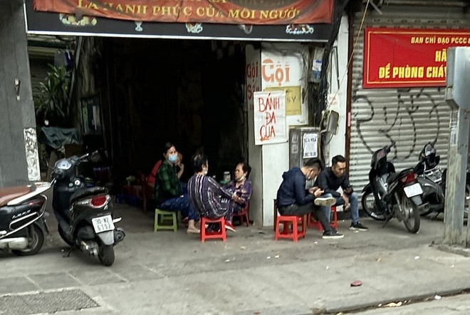 Các hàng quán tại phố Ngọc Lâm (quận Long Biên) bán trong nhà nay lấn chiếm vỉa hè để bán cho khách. (Ảnh: Minh Nghĩa/TTXVN) Hà Nội: Nhiều hàng quán không chấp hành quy định phòng chống dịch ảnh 1