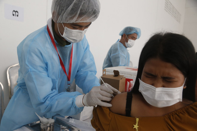 Nhân viên y tế tiêm vaccine phòng COVID-19 cho người dân tại Phnom Penh, Campuchia, ngày 1/6/2021. (Ảnh: THX/TTXVN) Campuchia tái áp đặt tình trạng "Vàng sậm" tại một số nơi ở Phnom Penh ảnh 1