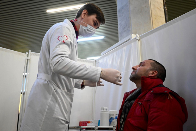 Nhân viên y tế lấy mẫu xét nghiệm COVID-19 cho người dân tại Moskva, Nga. (Ảnh: AFP/TTXVN) Nga ngày thứ 5 liên tiếp có hơn 20.000 ca mắc COVID-19 mỗi ngày ảnh 1