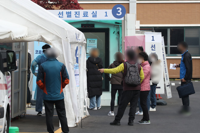Người dân chờ lấy mẫu xét nghiệm COVID-19 tại Seoul. (Ảnh: Yonhap/TTXVN) Hàn Quốc cân nhắc nâng mức giãn cách xã hội lên cấp độ 1,5 ảnh 1