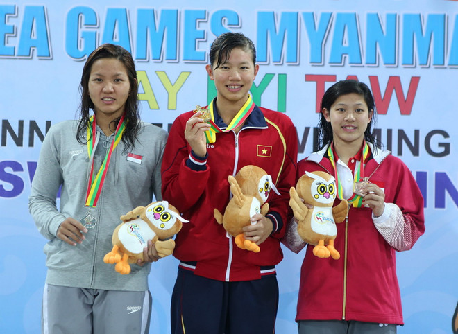 Vận động viên Nguyễn Thị Ánh Viên (giữa) trên bục nhận huy chương vàng nội dung 100m bơi ngửa nữ tại SEA Games 27. (Ảnh: TTXVN) Ánh Viên thắng tuyệt đối ở bình chọn VĐV tiêu biểu 2013 ảnh 1