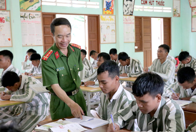 Đại úy Ngô Sỹ Thương hướng dẫn học cho phạm nhân. (Ảnh: Quang Thái/TTXVN) Lớp học nhân văn dành cho những phận đời không may lầm lỗi ảnh 2