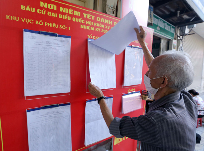 Người dân phường Hàng Bạc xem danh sách cử tri. (Ảnh: Hoàng Hiếu/TTXVN) Bầu cử Quốc hội và HĐND: Để lời hứa và kỳ vọng hòa cùng một nhịp ảnh 1