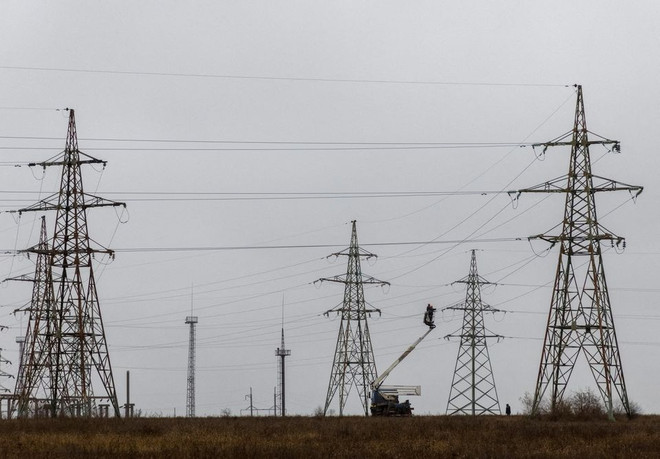 Nhân viên sửa chữa đường dây tải điện của Ukraine. (Ảnh: Reuters) Mỹ, EU tiếp tục hỗ trợ Ukraine tái thiết và bảo vệ cơ sở hạ tầng ảnh 1