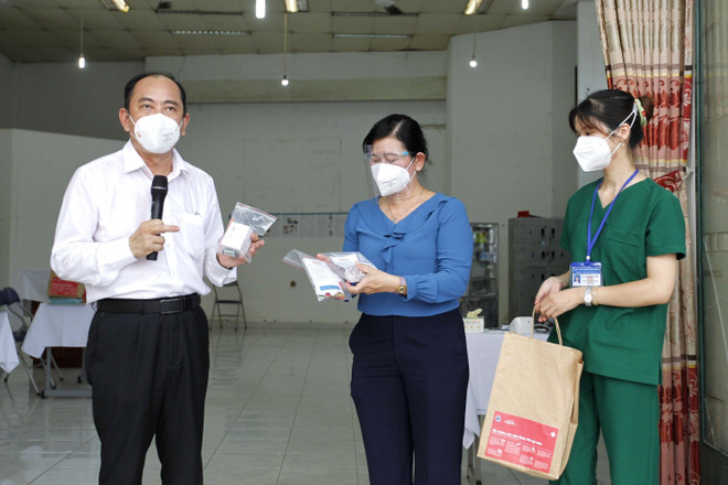 Phó Giám đốc Sở Y tế Thành phố Hồ Chí Minh giới thiệu túi thuốc phục vụ cho người mắc COVID-19 tại nhà. (Ảnh: Thanh Vũ/TTXVN) TP.HCM đưa thuốc Molnupiravir vào điều trị cho F0 triệu chứng nhẹ ảnh 1