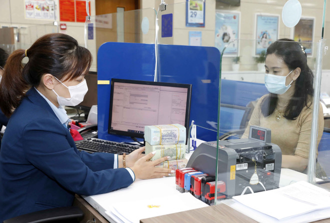 Khách hàng giao dịch tại VietinBank chi nhánh Ba Đình, Hà Nội. (Ảnh: TTXVN) Lãi suất huy động liên tiếp tăng, lãi suất cho vay khó giữ thấp ảnh 2