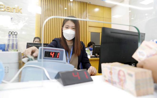 Làm thủ tục cho khách hàng vay vốn tại Ngân hàng Thương mại Cổ phần Bảo Việt. (Ảnh: TTXVN) Lãi suất huy động liên tiếp tăng, lãi suất cho vay khó giữ thấp ảnh 1