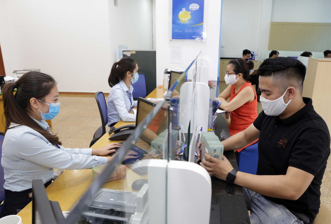 Các ngân hàng hỗ trợ người dân và doanh nghiệp bị ảnh hưởng bởi dịch COVID-19. (Ảnh minh họa: Trần Việt/TTXVN) Cổ phiếu ngân hàng: Động lực tăng trưởng đến từ đầu tư công ảnh 1