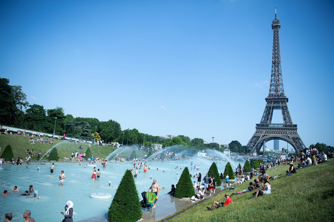 Người dân tại Paris (Pháp) tránh nóng tại các vòi phun nước ở gần tháp Eiffel. (Ảnh: THX/TTXVN) Biến đổi khí hậu: WMO cảnh báo 2019 có thể là năm nóng kỷ lục ảnh 1