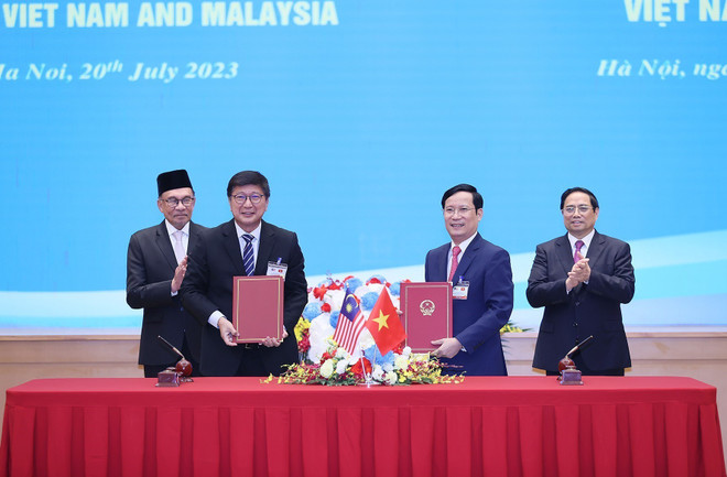 Thủ tướng Phạm Minh Chính và Thủ tướng Anwar Ibrahim chứng kiến lễ ký Bản ghi nhớ về hợp tác giữa Liên đoàn Thương mại và Công nghiệp Việt Nam với Phòng Thương mại và Công nghiệp Quốc gia Malaysia ngày 20/7/2023. (Ảnh: Dương Giang/TTXVN) Thủ tướng Anwar Ibrahim dự Diễn đàn Doanh nghiệp Việt Nam-Malaysia ảnh 1