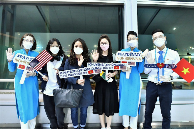 Hành khách chúc mừng Vietnam Airlines mở đường bay thường lệ đến Mỹ. (Ảnh: TTXVN) Kiến nghị giải pháp khôi phục các đường bay quốc tế thường lệ ảnh 2