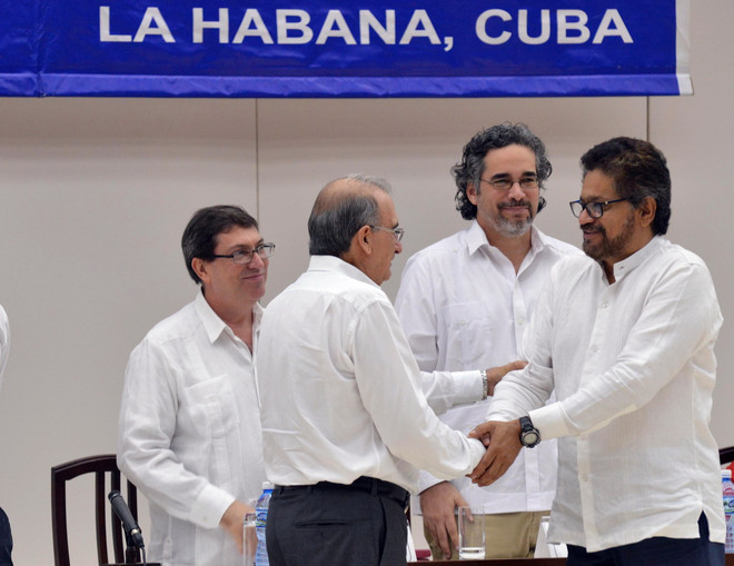 Đại diện Chính phủ Colombia (trái) và đại diện FARC (phải) tại lễ ký thỏa thuận hòa đàm, tại cuộc đàm phán ở Havana, Cuba ngày 15/12. (Ảnh: THX/TTXVN) Liên hợp quốc cam kết ủng hộ nỗ lực hòa đàm tại Colombia ảnh 1