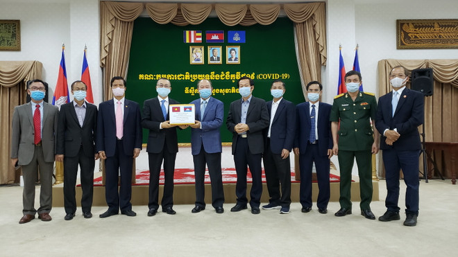 Đại diện Việt Nam và Campuchia chụp ảnh lưu niệm tại buổi trao tặng thiết bị y tế. (Ảnh: Nguyễn Hùng/TTXVN) Campuchia cảm ơn Việt Nam viện trợ thiết bị y tế chống dịch COVID-19 ảnh 1
