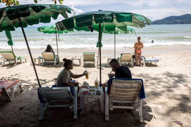 Du khách trên bãi biển ở Phuket, Thái Lan, ngày 14/8/2021. (Ảnh: AFP/TTXVN) Tham vọng thu hút khách du lịch của Thái Lan sau "Hộp cát Phuket" ảnh 2