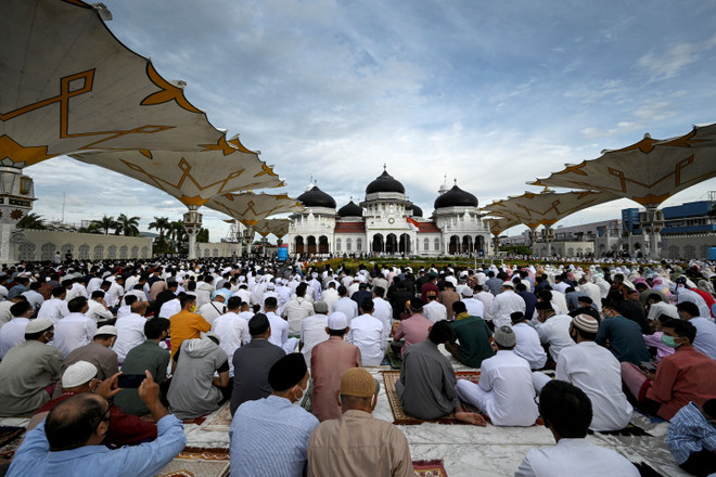 Các tín đồ Hồi giáo cầu nguyện bên ngoài một đền thờ ở Aceh, Indonesia để kỷ niệm lễ hiến sinh Eid al-Adha, ngày 20/7/2021. (Ảnh: AFP/TTXVN) Indonesia loay hoay đối phó giữa "cơn sóng thần" COVID-19 ảnh 1