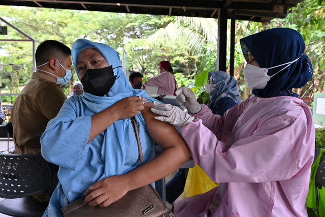Nhân viên y tế tiêm vaccine phòng COVID-19 cho người dân tại Jakarta, Indonesia, ngày 29/3/2022. (Ảnh: AFP/TTXVN) Số ca mắc tăng, Indonesia bước vào làn sóng dịch COVID-19 thứ tư ảnh 1
