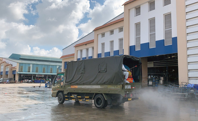 Lực lượng chức năng triển khai phun thuốc khử khuẩn tại khuôn viên chợ Bình Điền. (Ảnh: TTXVN phát) Đánh giá điều kiện mở lại chợ đầu mối, mạng lưới bán lẻ tại TP.HCM ảnh 2