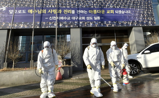 Nhân viên y tế phun thuốc khử trùng tại Daegu. (Ảnh: AFP/TTXVN) Hàn Quốc ghi nhận trường hợp tử vong đầu tiên do dịch COVID-19 ảnh 1