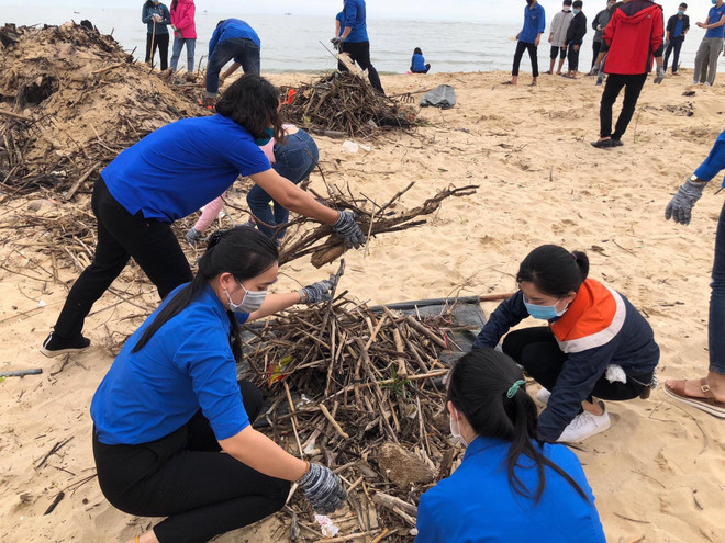 Các đoàn viên thanh niên thu gom rác thải và làm sạch bờ biển Nhật Lệ, thành phố Đồng Hới. (Ảnh: TTXVN phát) Tuổi trẻ Quảng Bình xung kích, chung tay bảo vệ môi trường ảnh 1