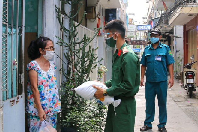 Các chiến sỹ bộ đội trao tặng lượng thực, thực phẩm tận nhà cho người lao động nghèo hẻm 139 Nguyễn Tiểu La, Quận 10. (Ảnh: Thanh Vũ/TTXVN) Bộ Xây Dựng kiểm tra hạ tầng phòng, chống dịch tại các tỉnh phía Nam ảnh 2