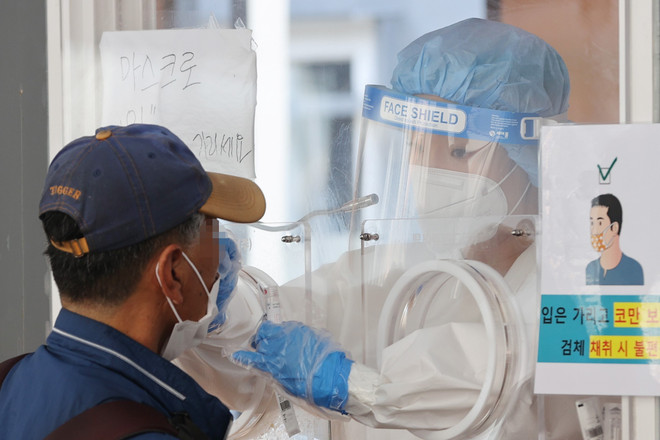 Nhân viên y tế lấy mẫu xét nghiệm COVID-19 tại Seoul, Hàn Quốc, ngày 20/6/2021. (Ảnh: YONHAP/TTXVN) Ngày thứ 5 liên tiếp Hàn Quốc ghi nhận trên 600 ca nhiễm mới ảnh 1
