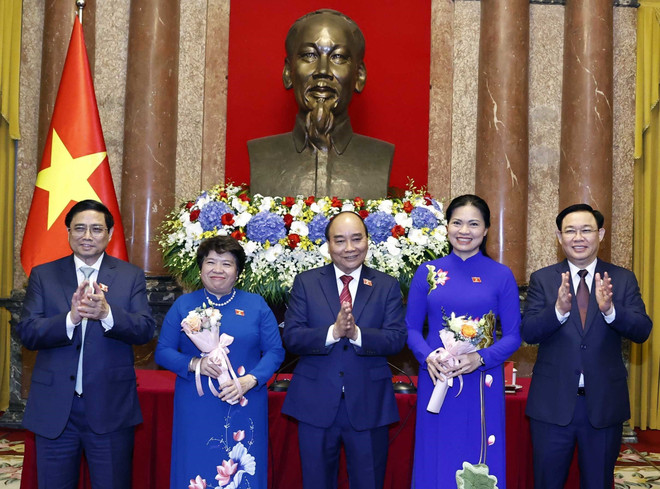 Chủ tịch nước Nguyễn Xuân Phúc, Thủ tướng Phạm Minh Chính, Chủ tịch Quốc hội Vương Đình Huệ tặng hoa chúc mừng đồng chí Hà Thị Nga, Chủ tịch Hội Liên hiệp Phụ nữ Việt Nam và đồng chí Nguyễn Thuý Anh, Chủ tịch Nhóm nữ đại biểu Quốc hội khoá XV. (Ảnh: Thống Nhất/TTXVN) Lãnh đạo Đảng, Nhà nước gặp mặt các nữ Đại biểu Quốc hội ảnh 2