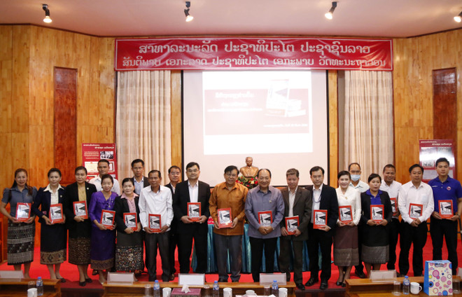 Đại diện các bộ ban ngành của Lào và Việt Nam dự lễ ra mắt cuốn sách cùng chụp ảnh lưu niệm. (Ảnh: Phạm Kiên/Vietnam+) Lào ra mắt cuốn sách về Đại sứ đặc mệnh đầu tiên của Việt Nam tại Lào ảnh 2