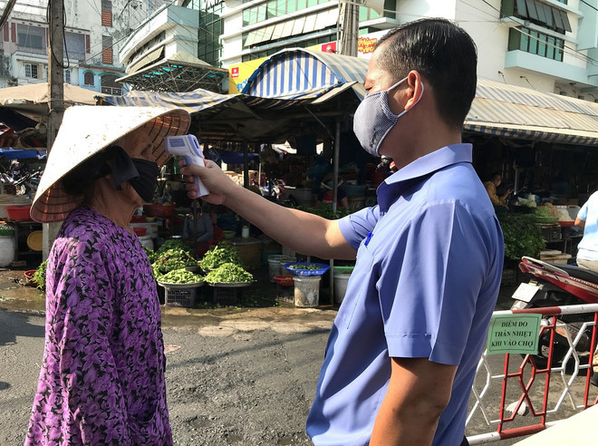 Kiểm tra thân nhiệt đối với người dân mua sắm tại chợ Vĩnh Long. (Ảnh: Lê Thúy Hằng/TTXVN) Các tỉnh phía Nam tiếp tục thực hiện nghiêm Chỉ thị 16 của Thủ tướng ảnh 2