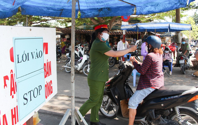 Người dân được đo thân nhiệt trước khi vào chợ Vị Thanh, thành phố Vị Thanh, tỉnh Hậu Giang. (Ảnh: Hồng Thái/TTXVN) Các tỉnh phía Nam tiếp tục thực hiện nghiêm Chỉ thị 16 của Thủ tướng ảnh 1