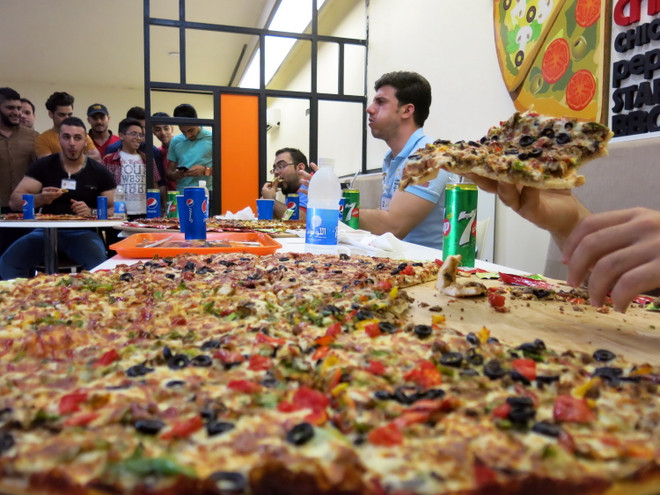 [Photo] Độc đáo cuộc thi ăn bánh pizza khổng lồ ở Baghdad ảnh 2