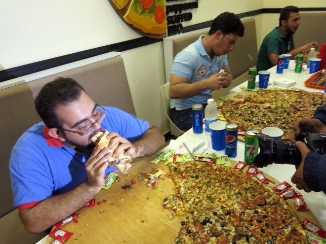 [Photo] Độc đáo cuộc thi ăn bánh pizza khổng lồ ở Baghdad ảnh 3