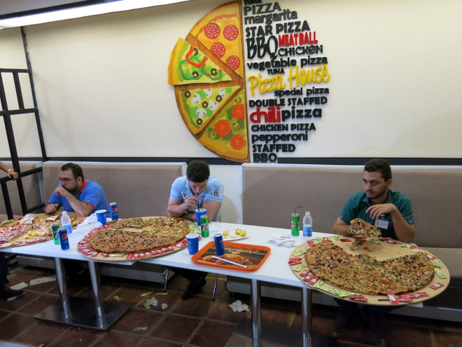 [Photo] Độc đáo cuộc thi ăn bánh pizza khổng lồ ở Baghdad ảnh 1