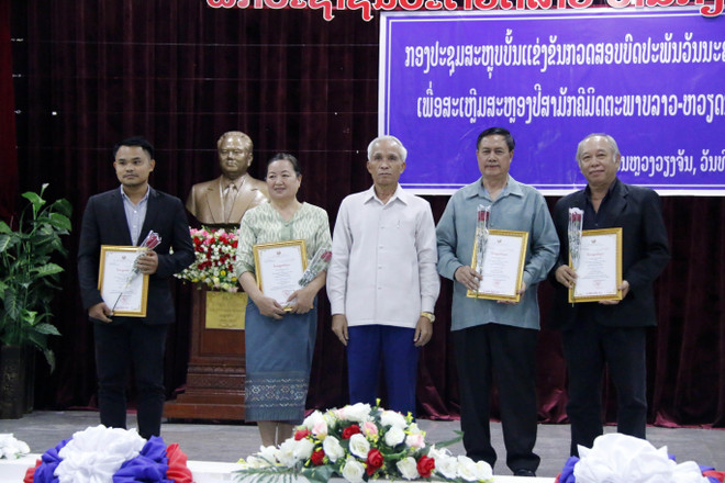Trưởng Ban Tuyên giáo Lào, ông Khamphan Pheuyavong (giữa) với các tác giả được giải nhì tại cuộc thi. (Ảnh: Phạm Kiên/TTXVN) Trao giải các tác phẩm văn học về quan hệ đặc biệt Việt Nam-Lào ảnh 2