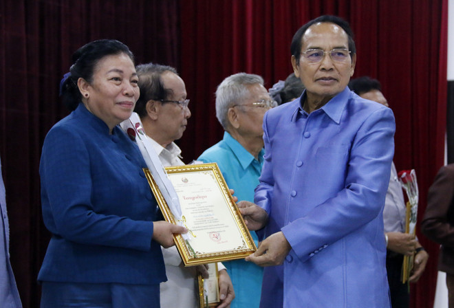 Ông Bounthong Chitmany, Ủy viên Bộ Chính trị, Thường trực Ban Bí thư, Phó Chủ tịch nước Lào trao phần thưởng cho các tác giả được giải tại cuộc thi. (Ảnh: Phạm Kiên/TTXVN) Trao giải các tác phẩm văn học về quan hệ đặc biệt Việt Nam-Lào ảnh 1