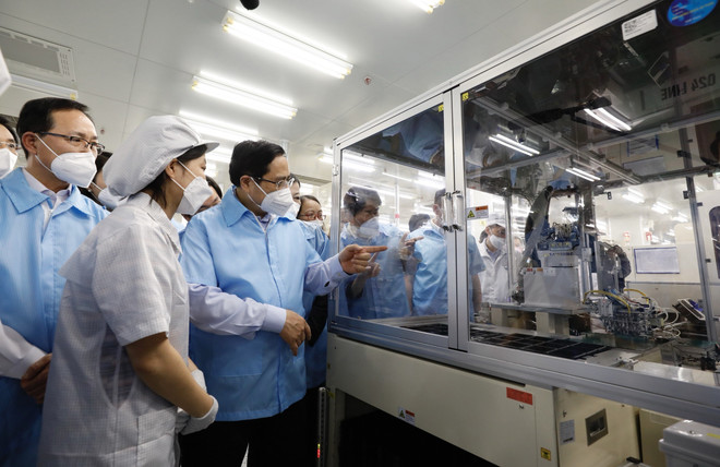 Thủ tướng Phạm Minh Chính tham quan dây chuyền sản xuất của Công ty TNHH Samsung Electronics Việt Nam Thái Nguyên. (Ảnh: Dương Giang/TTXVN) Dịch COVID-19: Để doanh nghiệp FDI yên tâm đầu tư lâu dài tại Việt Nam ảnh 1